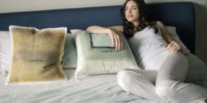A woman laying on a bed with pillows.