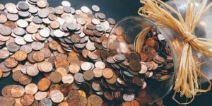 A bowl full of coins with a straw tied around it.