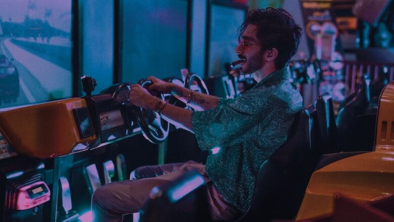 A cheerful man playing a video game in an arcade slot machine.