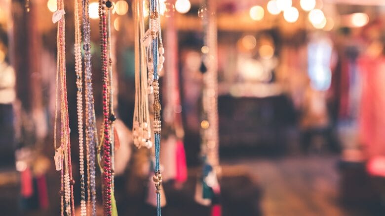 A group of beaded necklaces hanging in a store.