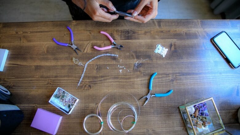 A woman is working with a pair of scissors on a table.