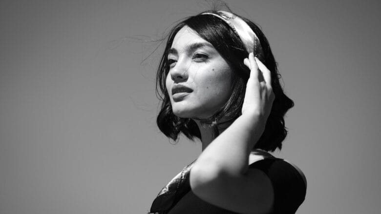 A black and white photo of a woman wearing a headband.