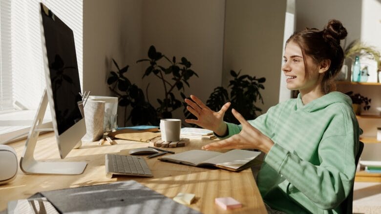 A woman is sitting at a desk in front of a computer.