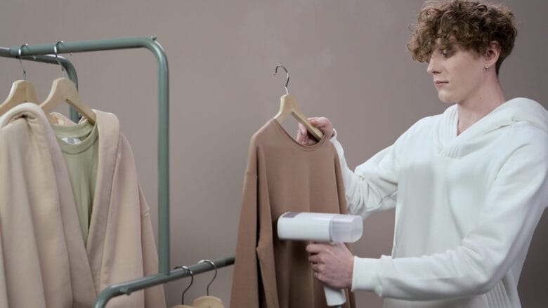 A man is drying clothes on a rack.