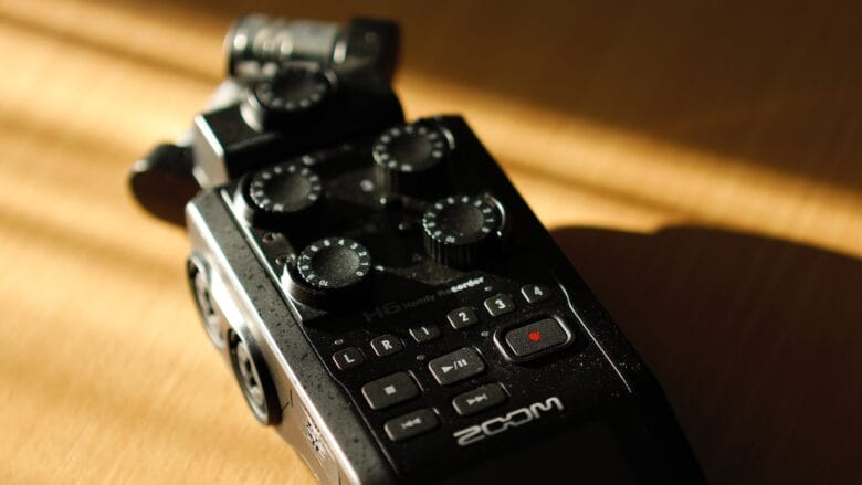 A digital recorder sitting on a wooden table.